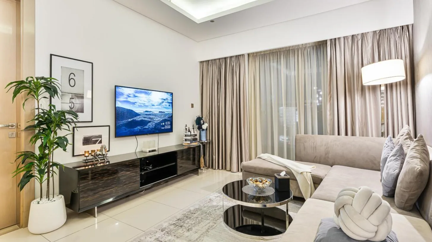 a bedroom with a bed and a desk and a television at Luxury 1BR with Burj Khalifa View 5-Star Amenities & Valet Parking in Dubai