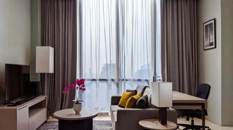 a living room with a couch and a table and a window at Mangkuluhur Residences by Lorin in Jakarta