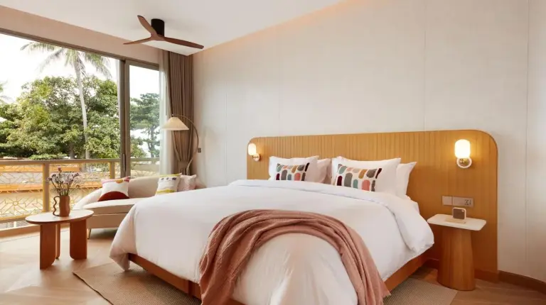 a bedroom with a large bed and a large window at Marasca Samui - Small Luxury Hotels of the World in Chaweng