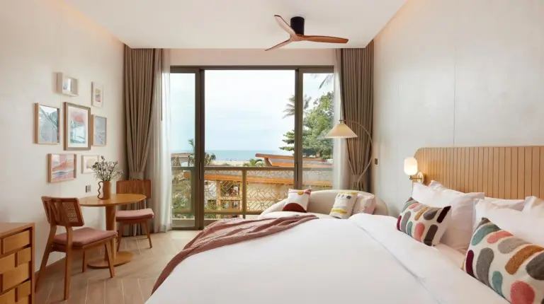 a hotel room with a bed and a large window at Marasca Samui - Small Luxury Hotels of the World in Chaweng