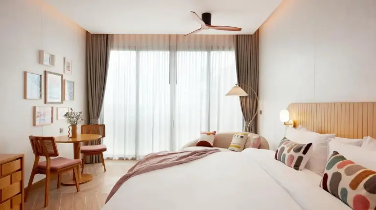 a hotel room with a bed and a table at Marasca Samui - Small Luxury Hotels of the World in Chaweng