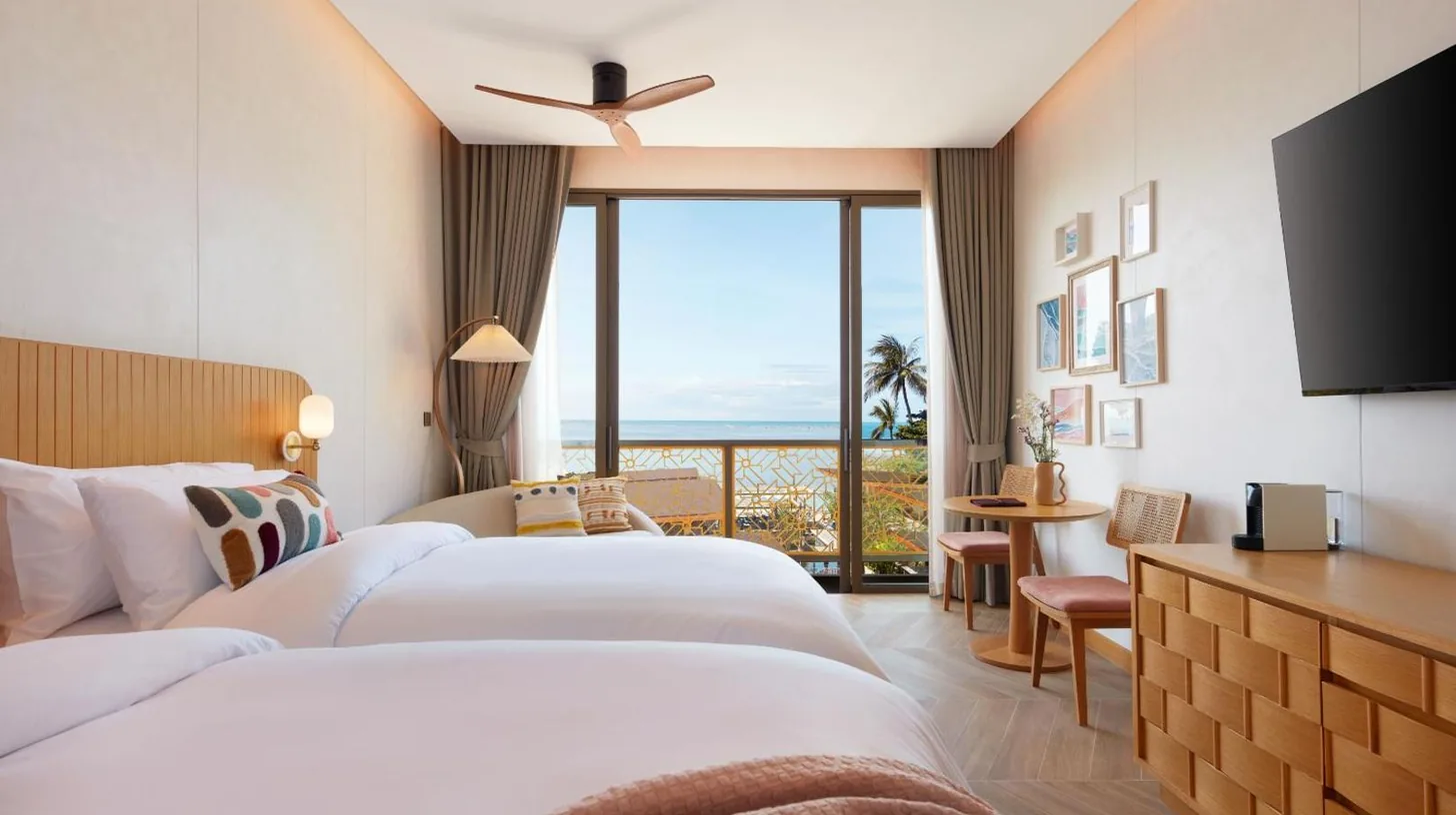 a hotel room with two beds and a large window at Marasca Samui - Small Luxury Hotels of the World in Chaweng