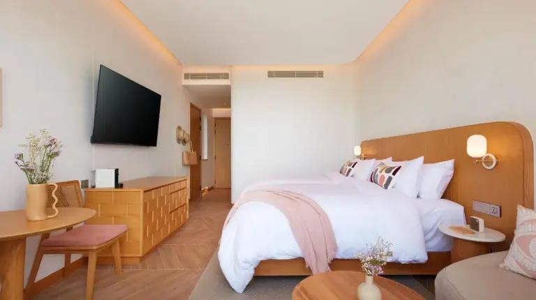 a hotel room with a bed and a tv at Marasca Samui - Small Luxury Hotels of the World in Chaweng