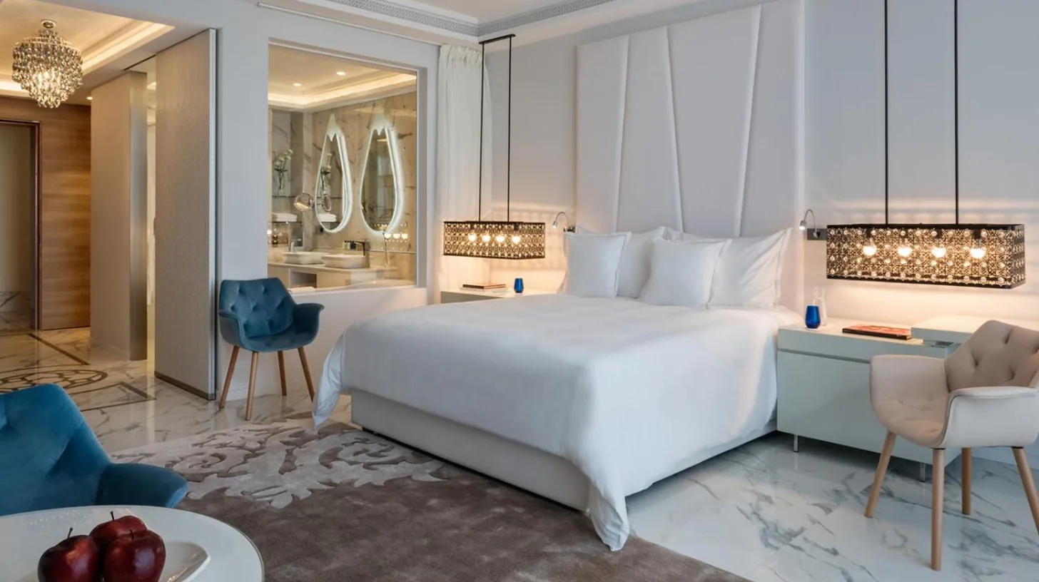 a bedroom with a large white bed and a living room at Marchica Lagoon Resort in Nador
