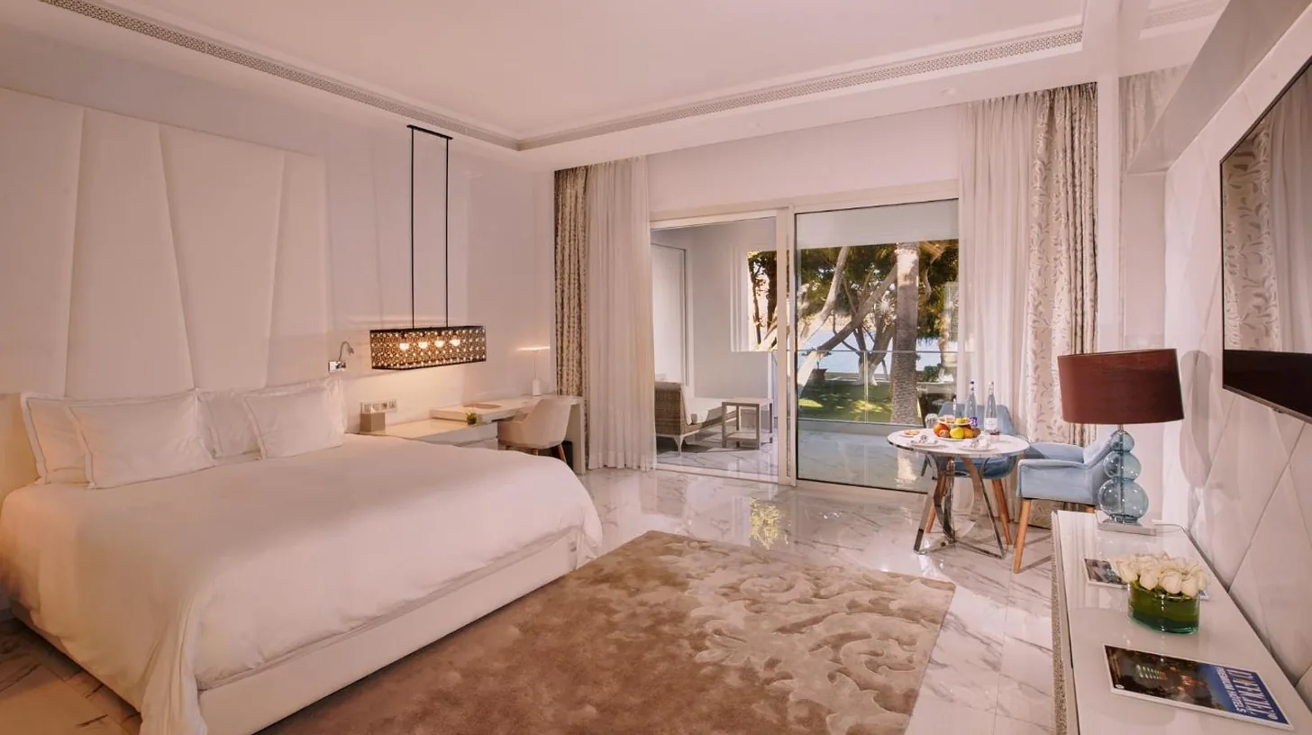 a bedroom with a white bed and a living room at Marchica Lagoon Resort in Nador