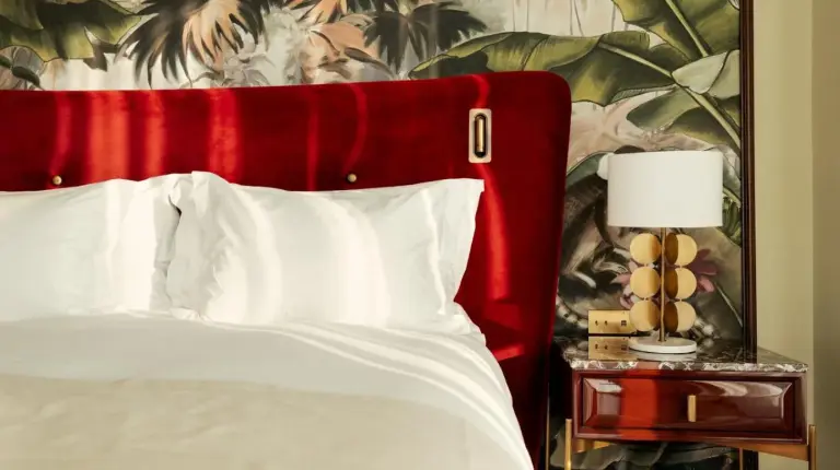 a bed with a red headboard and a table with a lamp at Marly Boutique Hôtel in Casablanca
