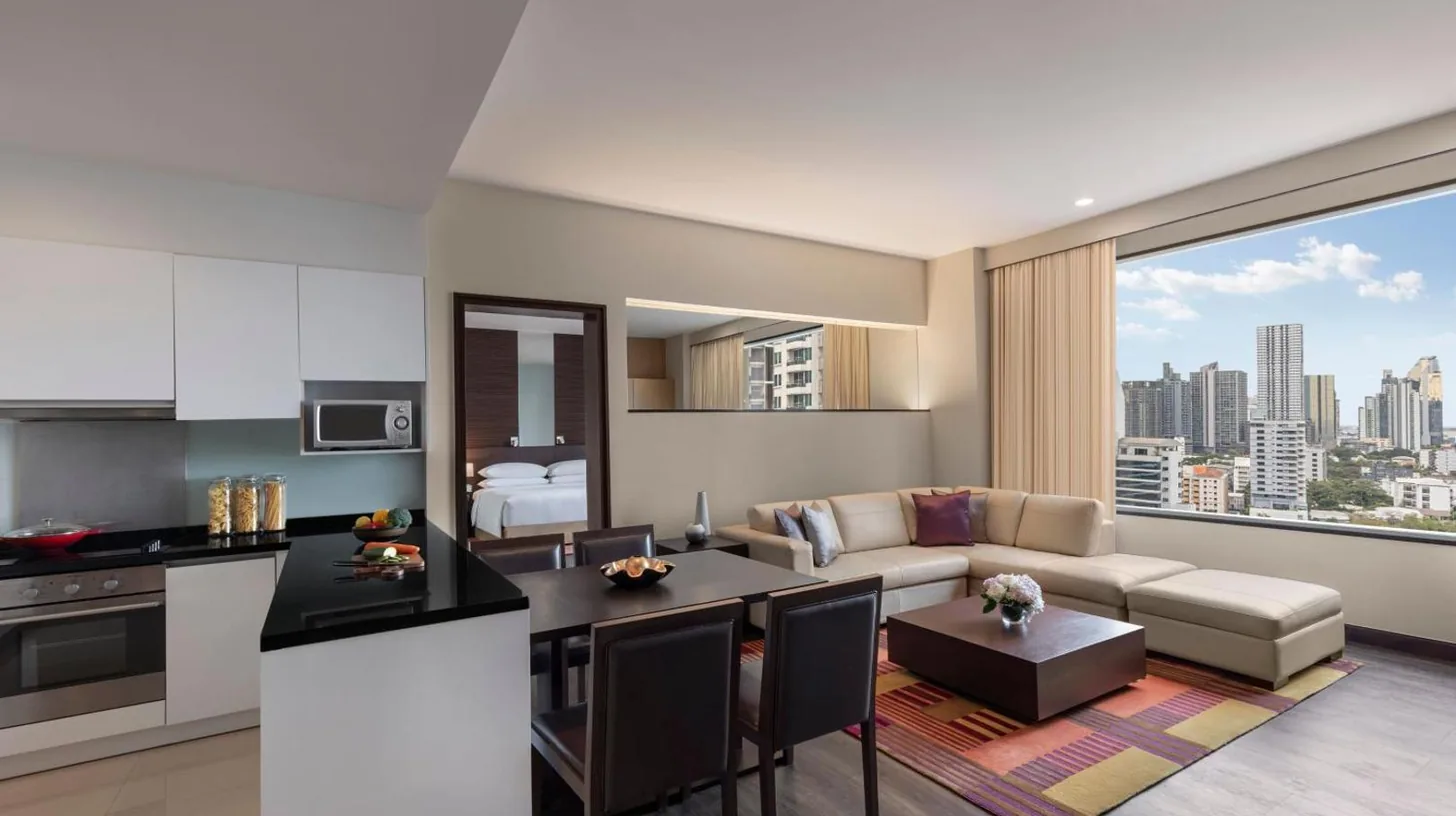 a kitchen and living room with a couch and a table at Marriott Executive Apartments Sukhumvit Park