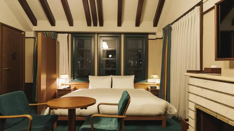 a hotel room with a blue couch and a bed at Marufukuro in Kyoto