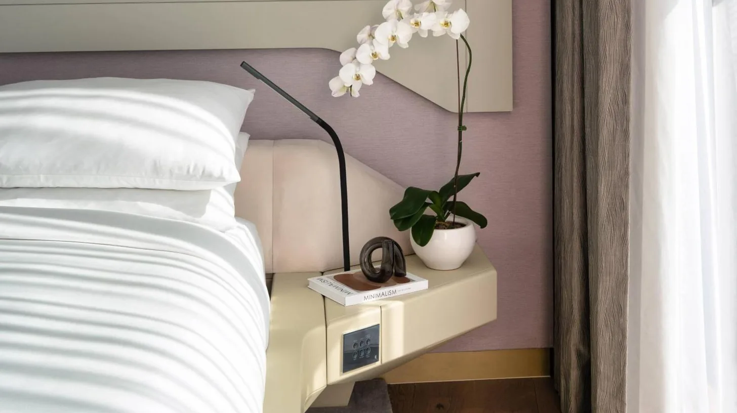 un dormitorio con una cama y una planta sobre una mesita de noche en ME by Meliá Dubai Residences en Dubái