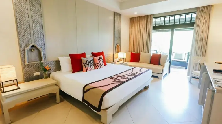 Ein Schlafzimmer mit großem Bett und Wohnbereich im Melati Beach Resort & Spa am Choeng Mon Beach