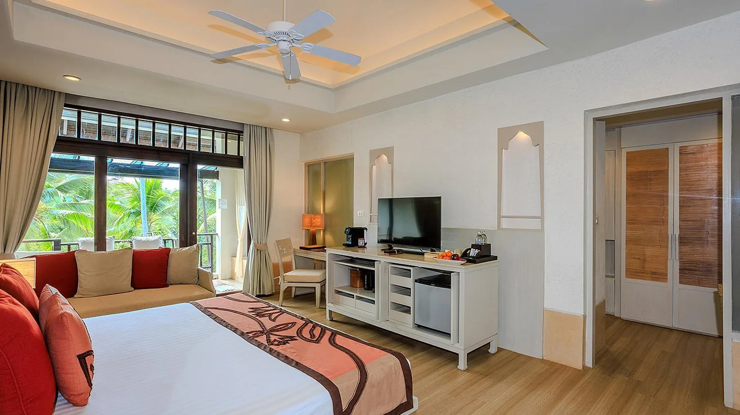 Ein Schlafzimmer mit Bett, TV und Sofa im Melati Beach Resort & Spa am Choeng Mon Beach
