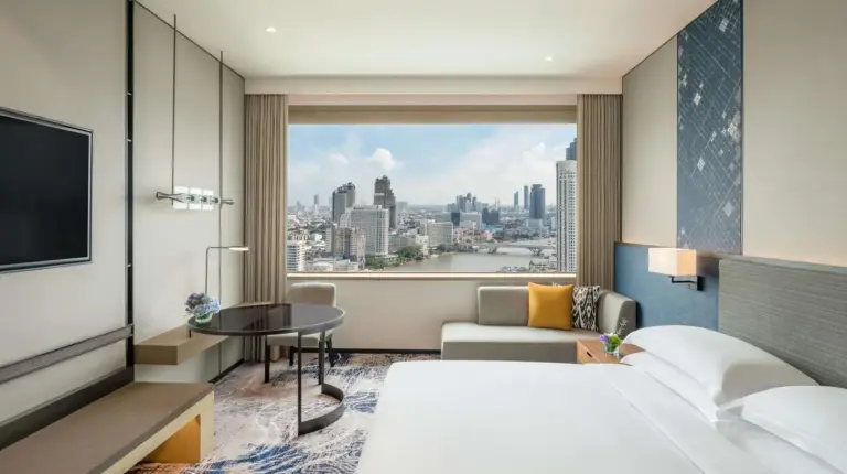 a living room with a couch and a table at Millennium Hilton Bangkok in Bangkok