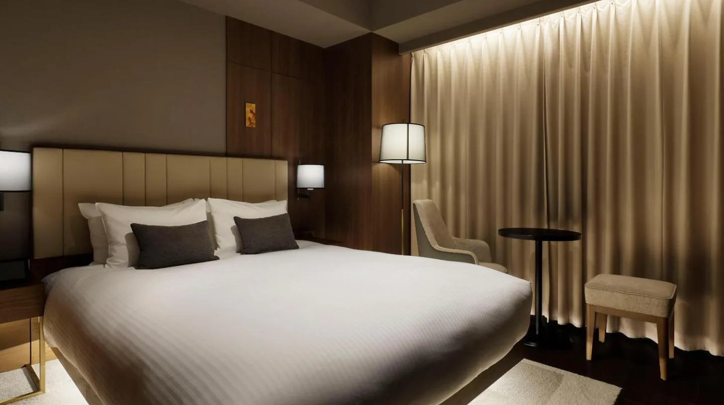 a bedroom with a large white bed and a piano at Mitsui Garden Hotel Roppongi Tokyo Premier in Tokyo
