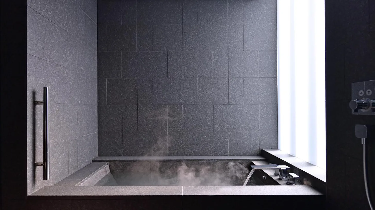 a bath tub with steam in a black bathroom at MOGANA in Kyoto