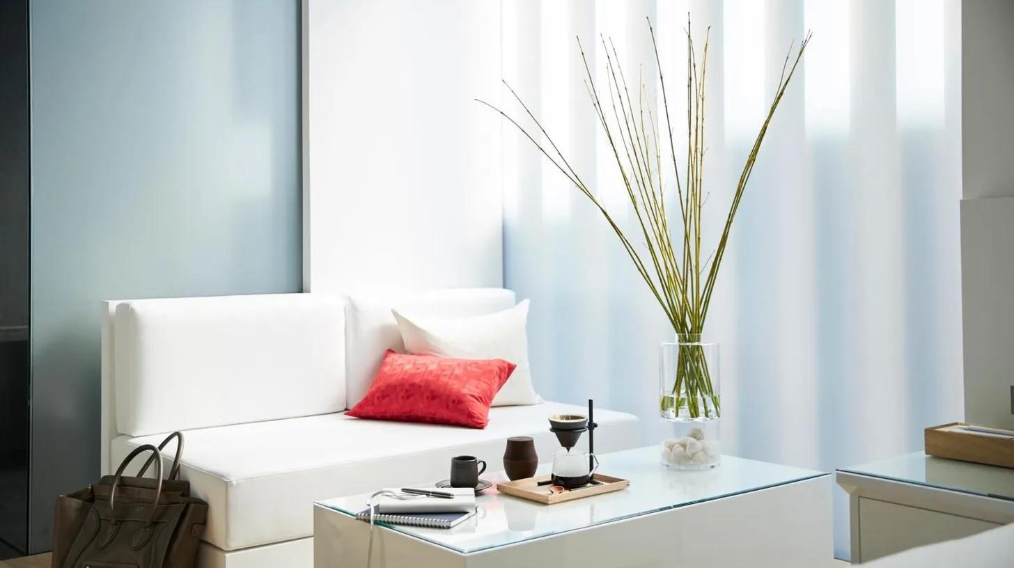 a living room with a white couch with a red pillow at MOGANA in Kyoto