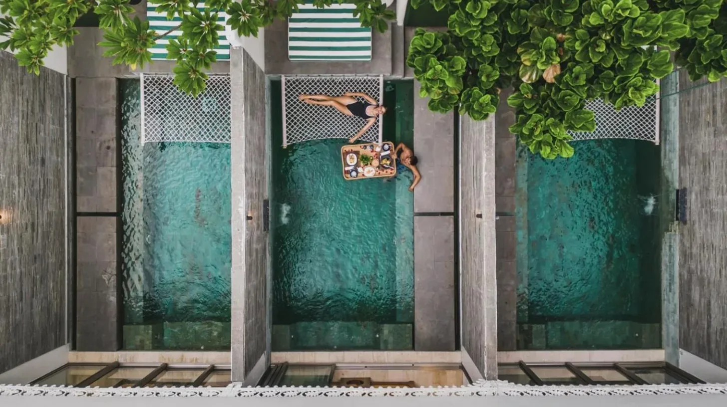 a person jumping off the front door of a building at Monolocale Resort & Spa Seminyak by Ini Vie Hospitality in Seminyak