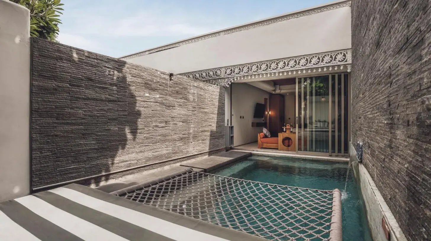a bedroom with three beds and a large window at Monolocale Resort & Spa Seminyak by Ini Vie Hospitality in Seminyak