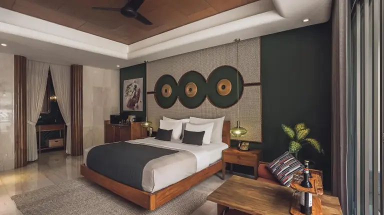 a swimming pool with a bed next to a house at Monolocale Resort & Spa Seminyak by Ini Vie Hospitality in Seminyak