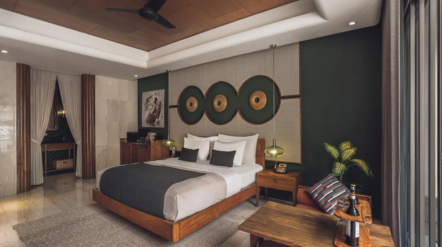 a swimming pool with a bed next to a house at Monolocale Resort & Spa Seminyak by Ini Vie Hospitality in Seminyak