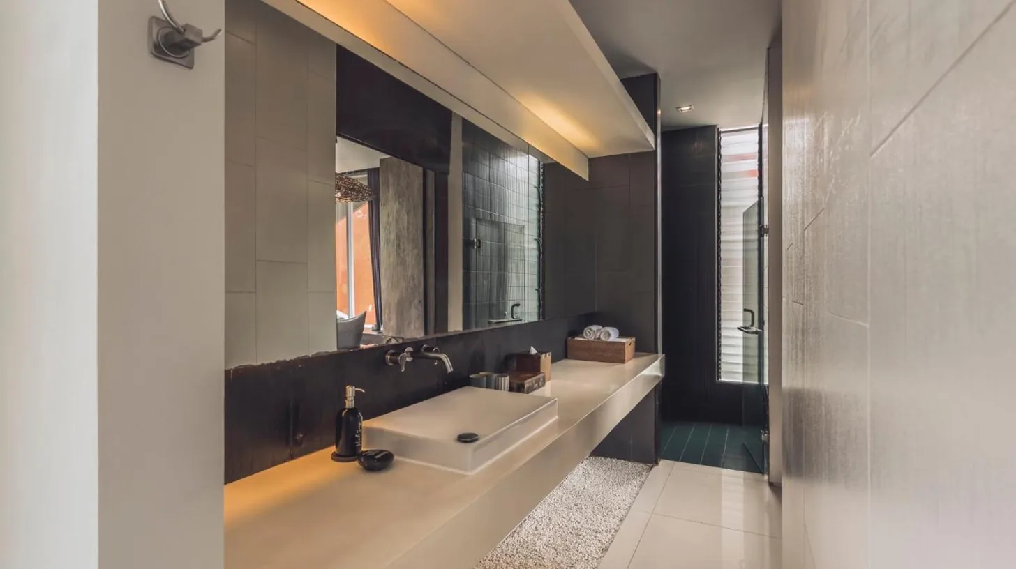 a bedroom with a large bed and a table at Monolocale Resort & Spa Seminyak by Ini Vie Hospitality in Seminyak