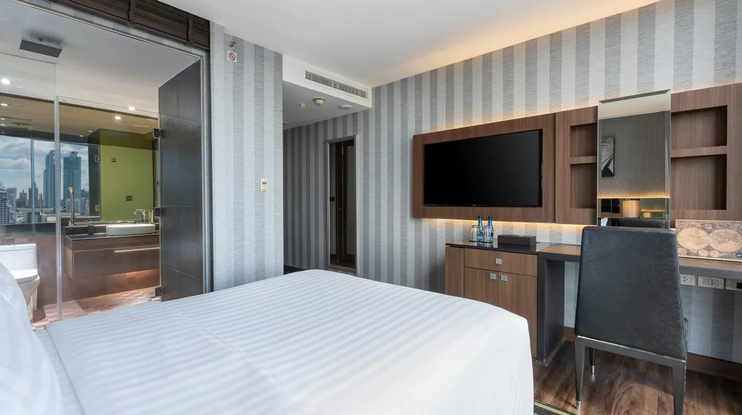 a bathroom with a white sink and a shower at Montraj Continent Sukhumvit Bangkok in Bangkok