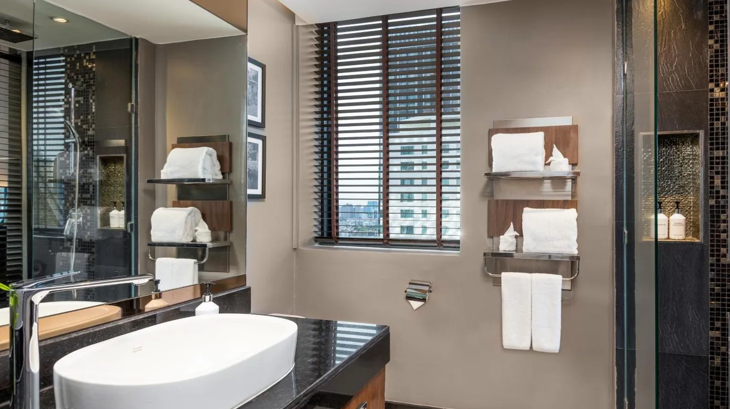 a bedroom with a bed and a large window at Montraj Continent Sukhumvit Bangkok in Bangkok