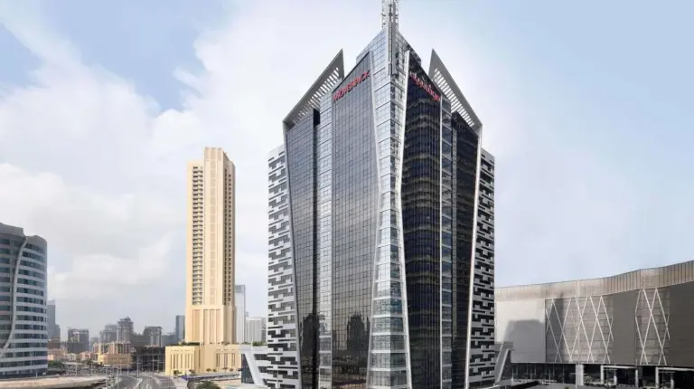 a tall building with a cross on top of it at Mövenpick Hotel Apartments Downtown Dubai in Dubai