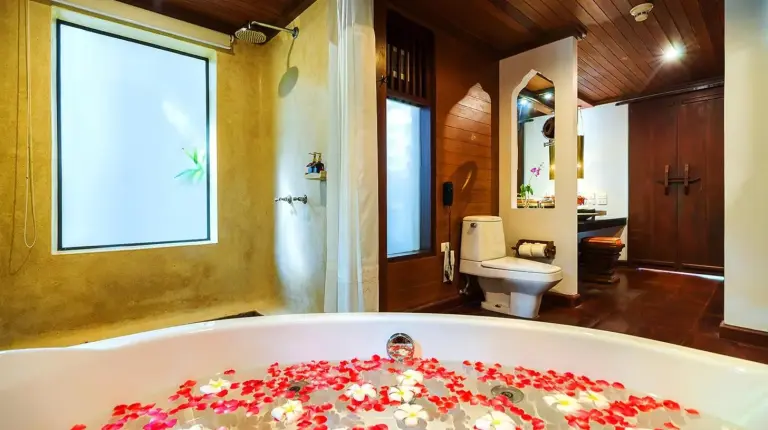 a bathroom with a tub with flowers on it at Muang Samui Spa Resort in Chaweng