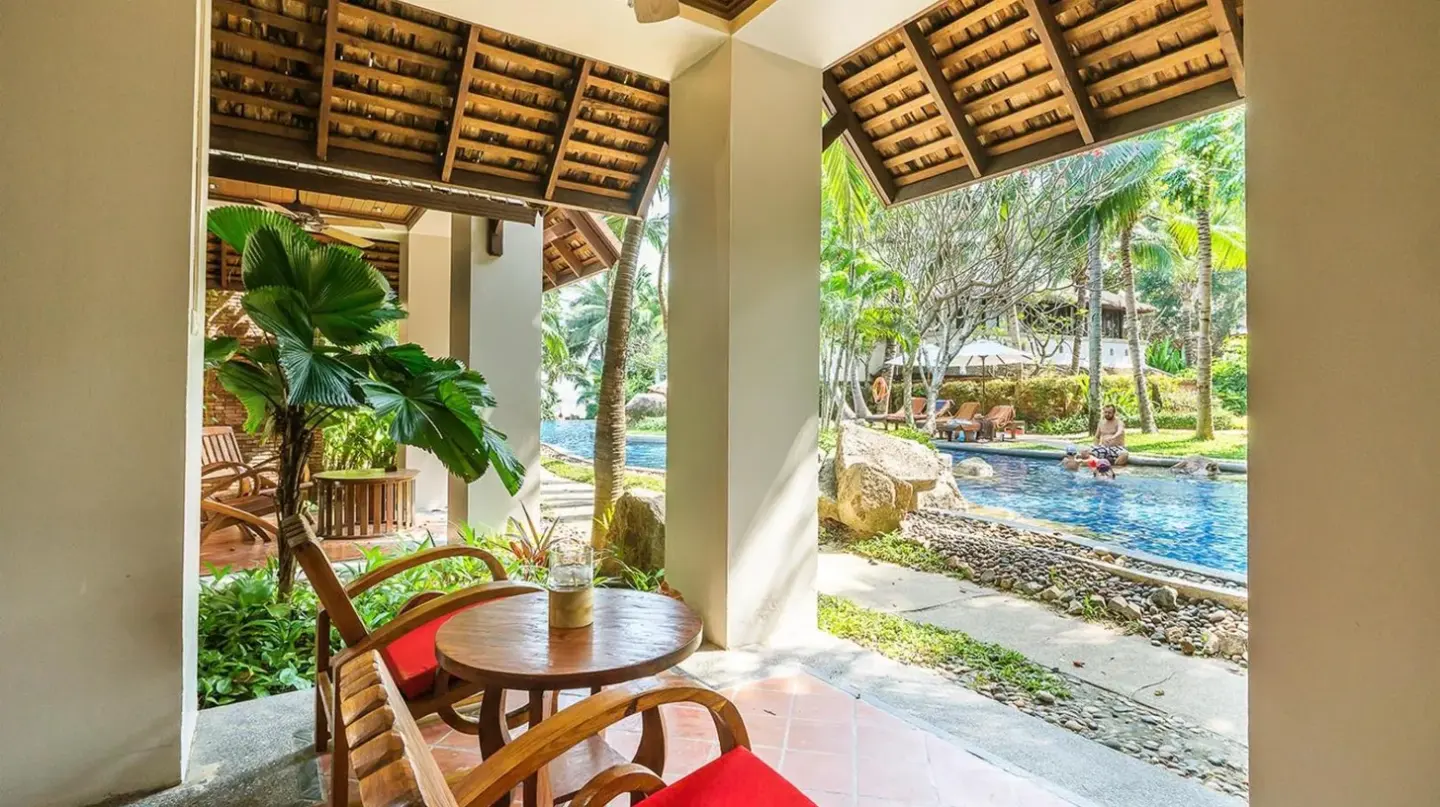 a patio with a table and chairs and a pool at Muang Samui Spa Resort in Chaweng
