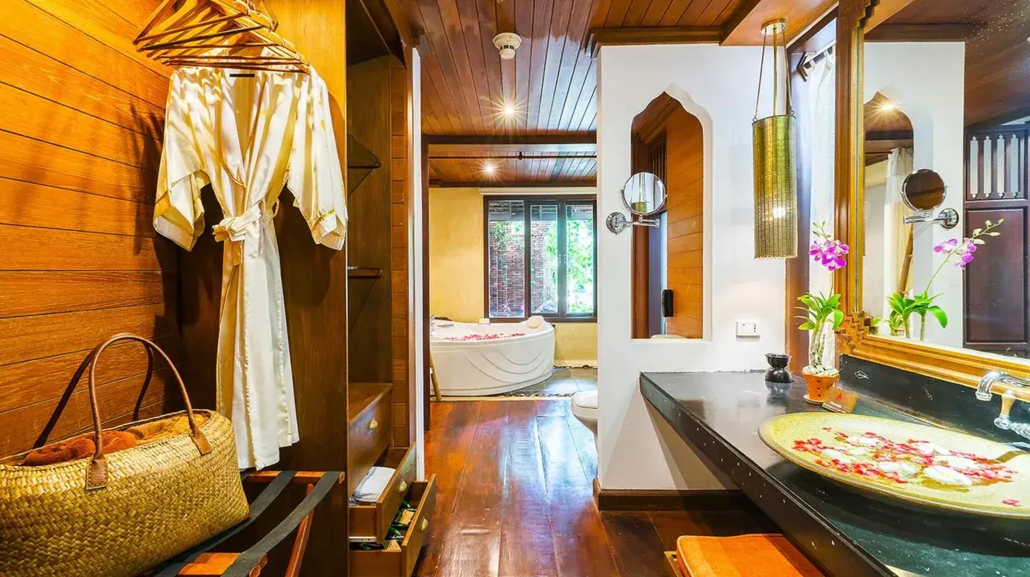 a bathroom with a sink and a mirror and a tub at Muang Samui Spa Resort in Chaweng