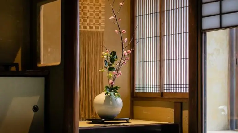 a room with a vase with a plant in it at Nazuna Kyoto Gosho in Kyoto