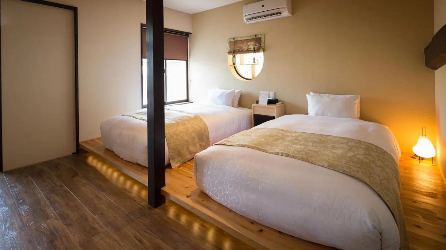 une chambre d’hôtel avec deux lits et une fenêtre au Nazuna Kyoto Nijo-jo à Kyoto