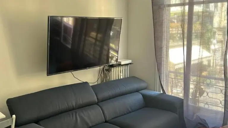 a living room with a blue couch and a tv at New central nice sea down town in Nice