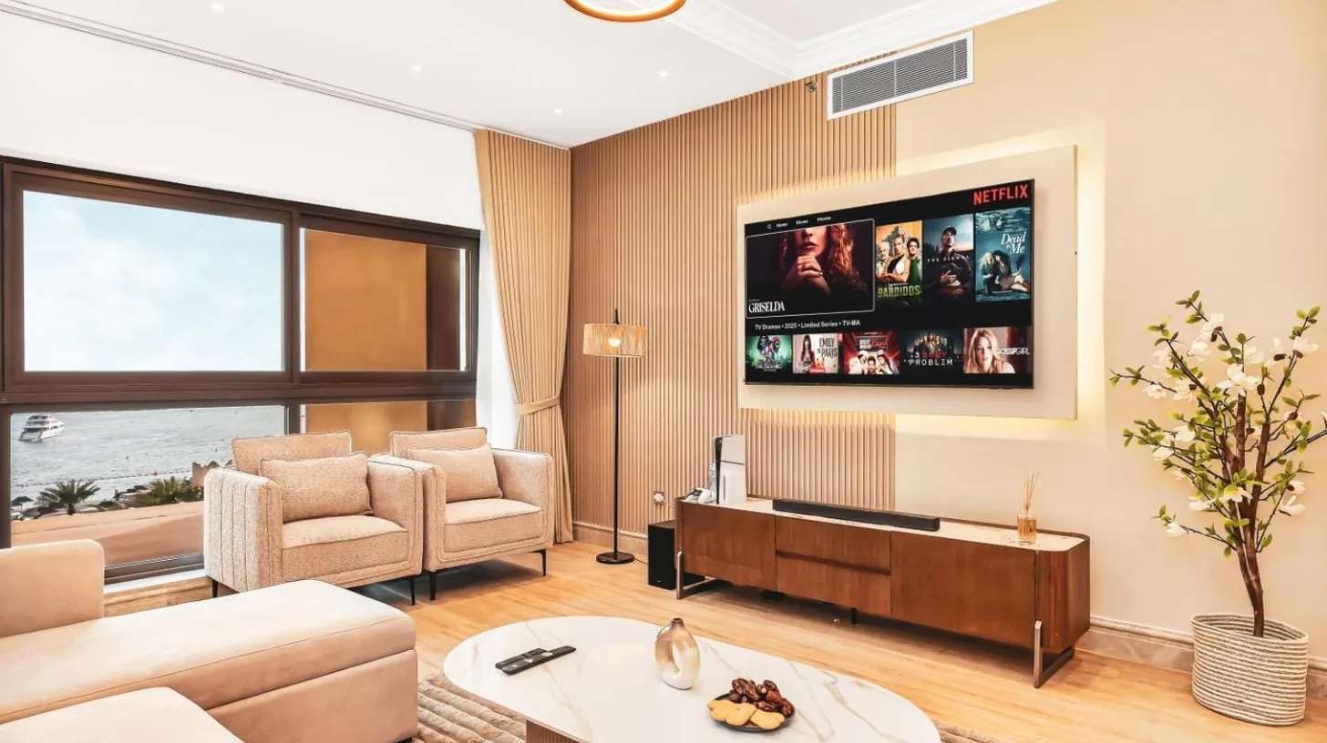 a living room with a couch and a tv at New Fairmont Residence with private beach on Palm Jumeirah in Dubai