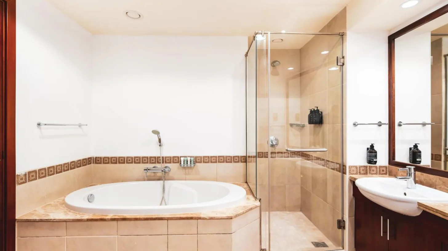 a bathroom with a tub and a shower and a sink at New Fairmont Residence with private beach on Palm Jumeirah in Dubai