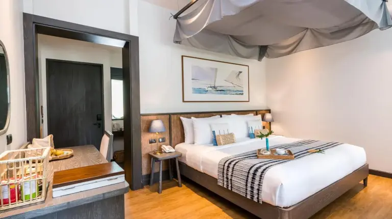 une salle de bain avec deux lavabos et miroir au NH Collection Samui Peace Resort à Bophut