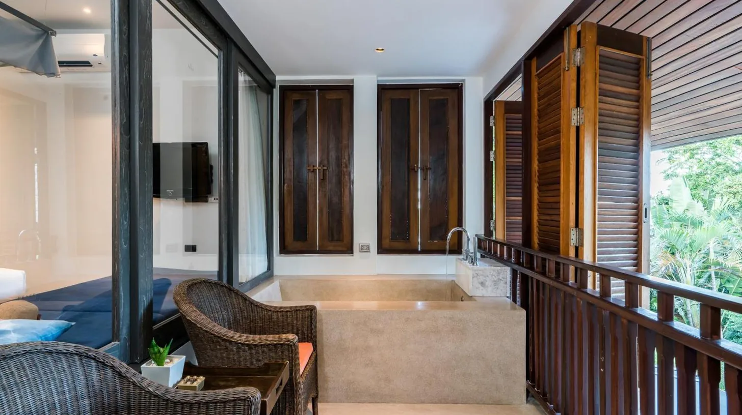 une salle de bain blanche avec baignoire et fenêtre au NH Collection Samui Peace Resort à Bophut