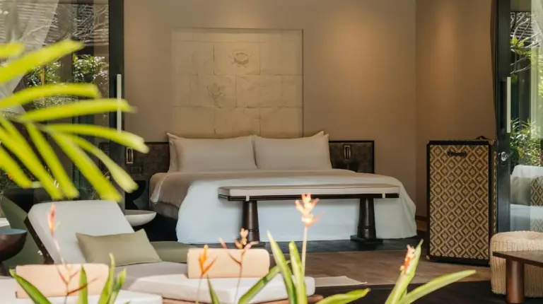 a bedroom with a bed and a couch at Nikki Beach Resort & Spa Koh Samui in Lipa Noi