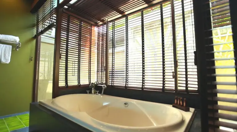 a bath tub in a bathroom with a window at Nora Buri Resort & Spa in Chaweng