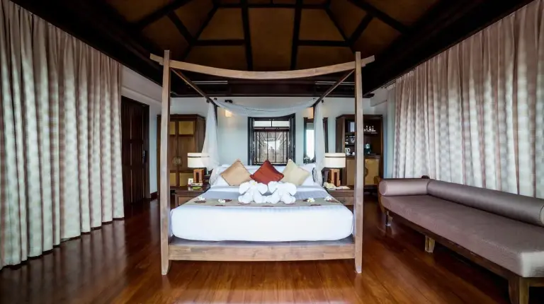 a bedroom with a large bed and a couch at Nora Buri Resort & Spa in Chaweng