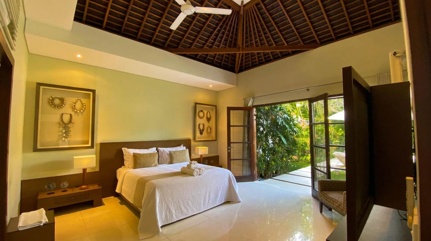 a bedroom with a bed and a large window at Nyaman Villas Seminyak in Seminyak