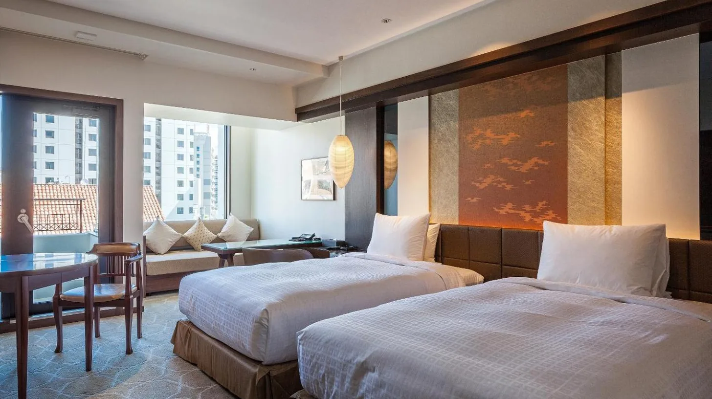a hotel room with two beds and a table at Okinawa EXES Naha in Naha