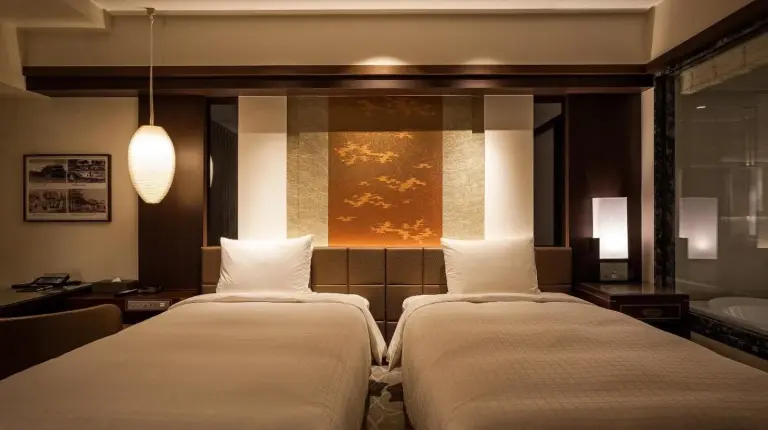 two beds in a hotel room with a bathroom at Okinawa EXES Naha in Naha