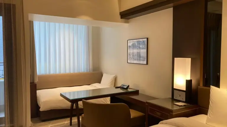 a hotel room with a desk and a bed at Okinawa EXES Naha in Naha