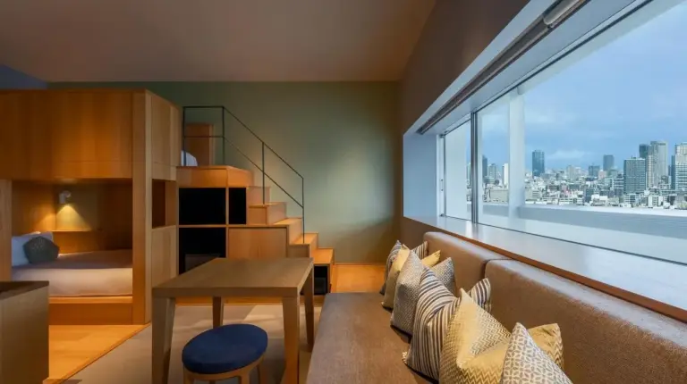 a bed with white sheets and pillows in a room at OMO7 Osaka by Hoshino Resorts in Osaka