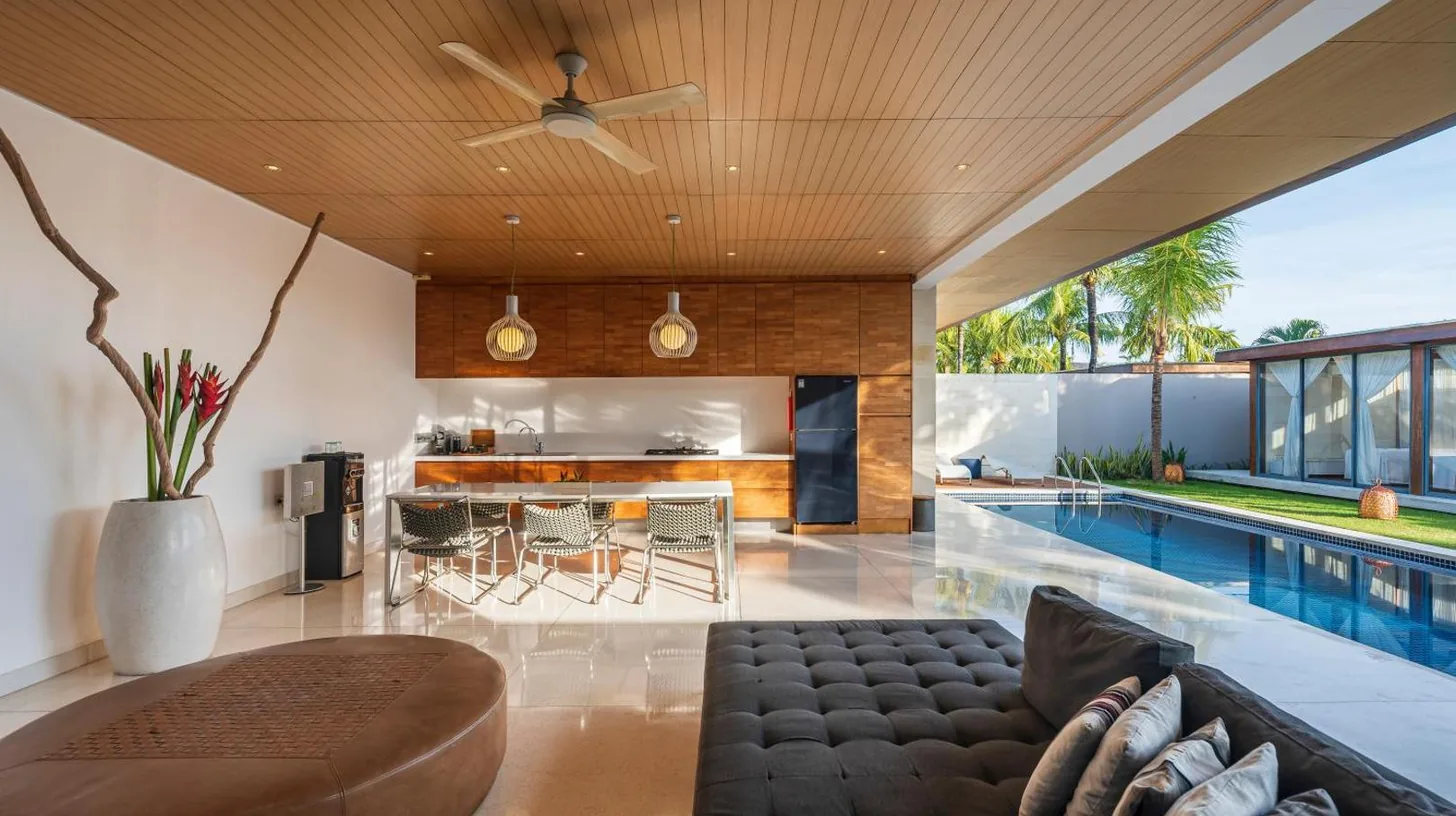 an open living room with a couch and a swimming pool at One Eleven Retreat in Seminyak