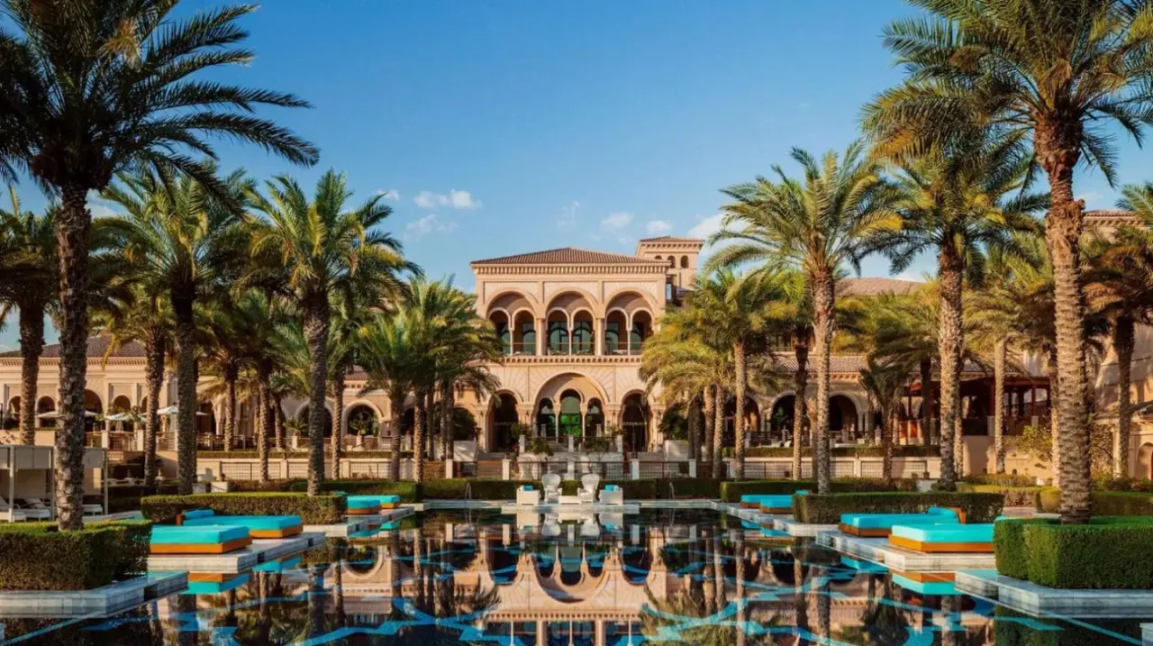 a resort with palm trees in front of a building at One&Only The Palm Dubai in Dubai