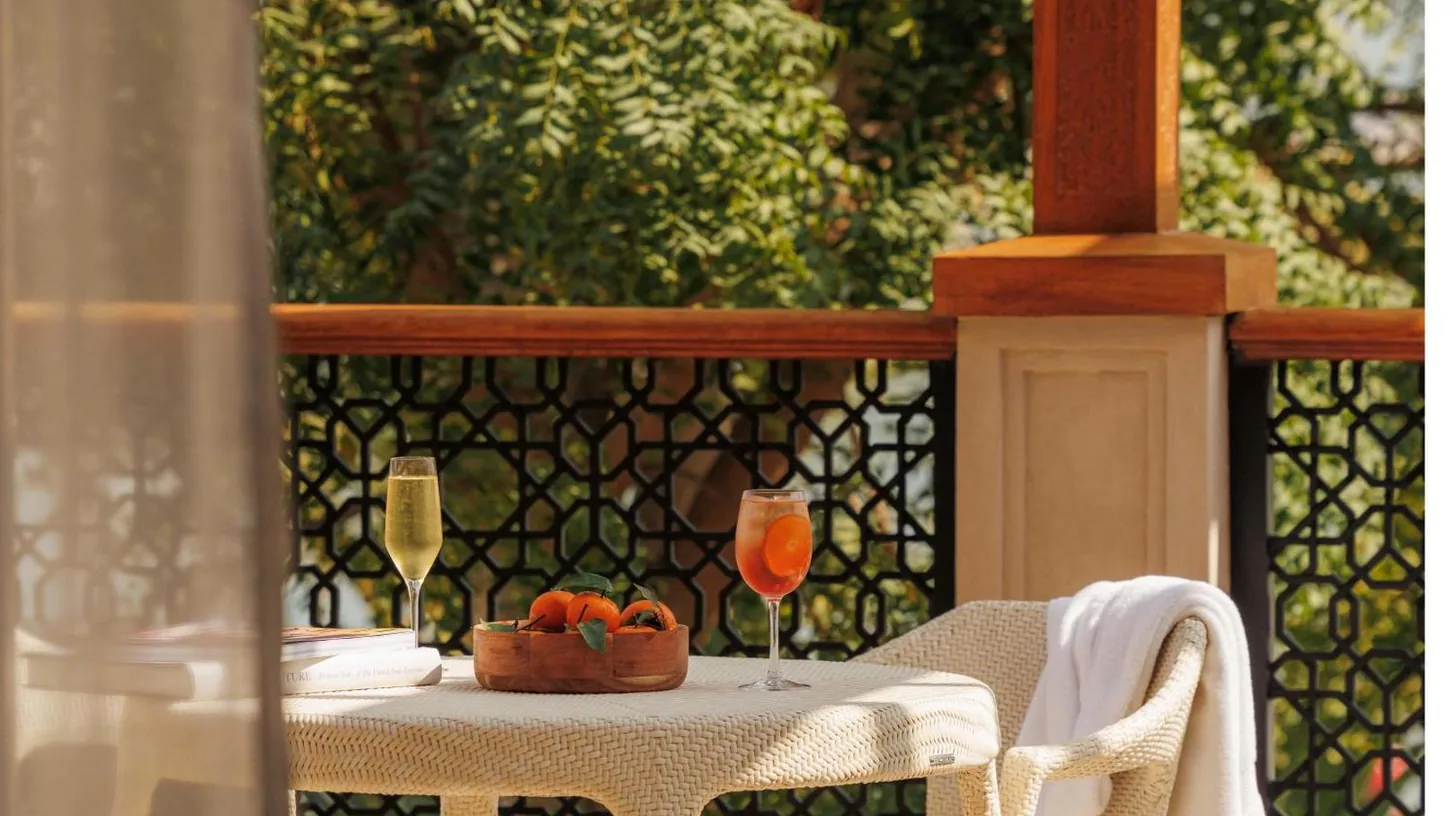 a table with a bowl of fruit and a glass of wine at One&Only The Palm Dubai in Dubai