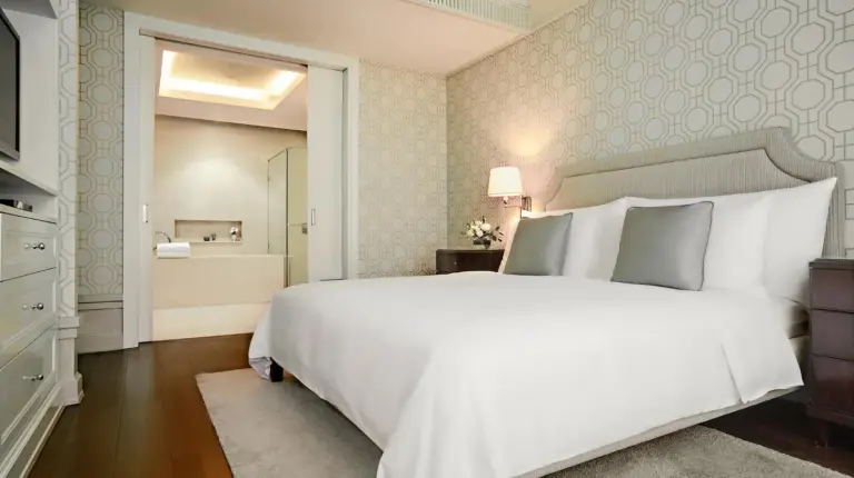 una habitación con una cama grande blanca y un baño en Oriental Residence Bangkok en Bangkok