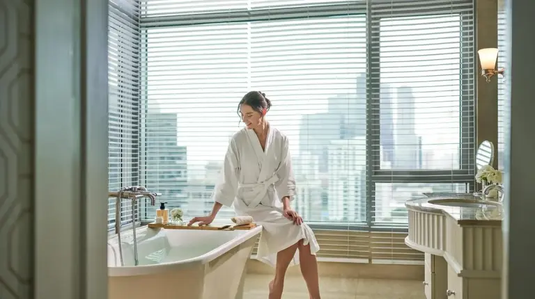 una mujer sentada en una bañera en un baño en Oriental Residence Bangkok en Bangkok